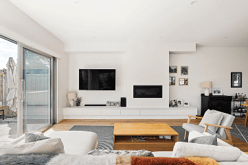 Modern living room with large glass sliding doors, contemporary furniture, and a sleek fireplace, showcasing stylish interior design at Ember Estate Agents' property listing.