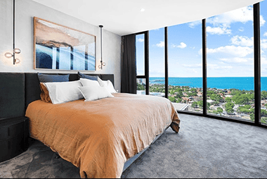 Modern bedroom with panoramic ocean views, large windows, and contemporary décor showcasing luxury property at Ember Estate Agents in Australia.