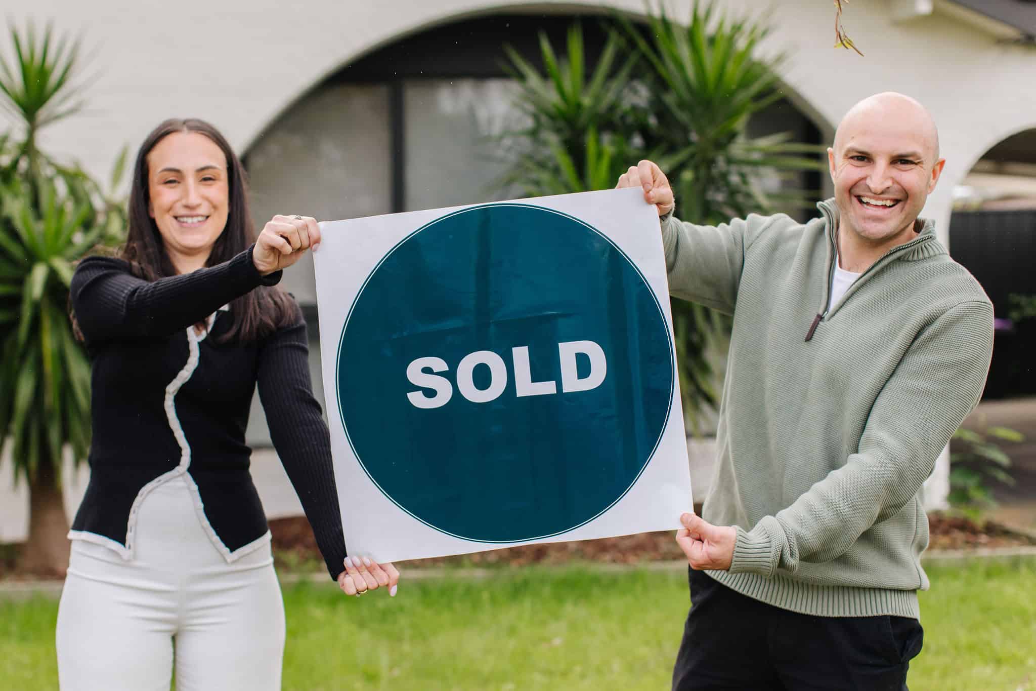 Sold sign at Ember Estate Agents, showcasing a successful property sale in a lush residential area with greenery and modern architectural elements.