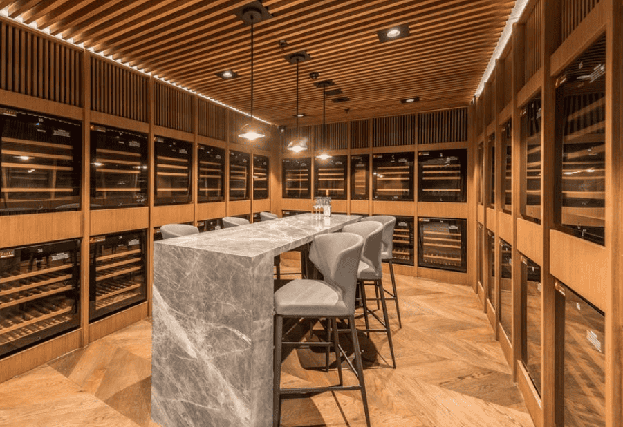 Luxurious wine cellar with elegant marble tasting table and modern bar stools at Ember Estate Agents, showcasing premium property interior design in Australia.