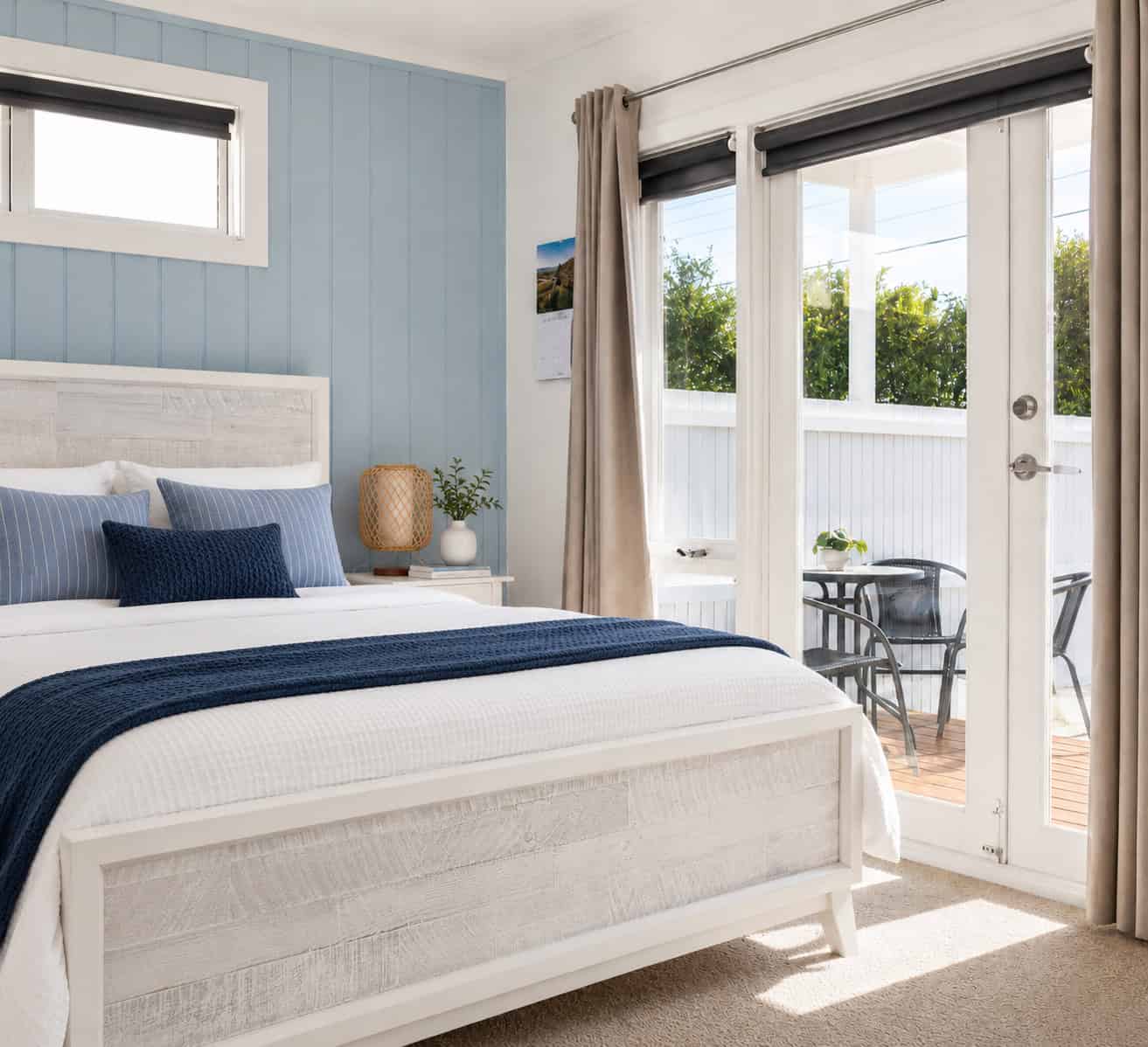 Bright, airy bedroom with north-facing windows in a prime Chelsea location, featuring modern decor and outdoor access. Perfect for buyers seeking a comfortable, sunlit home.