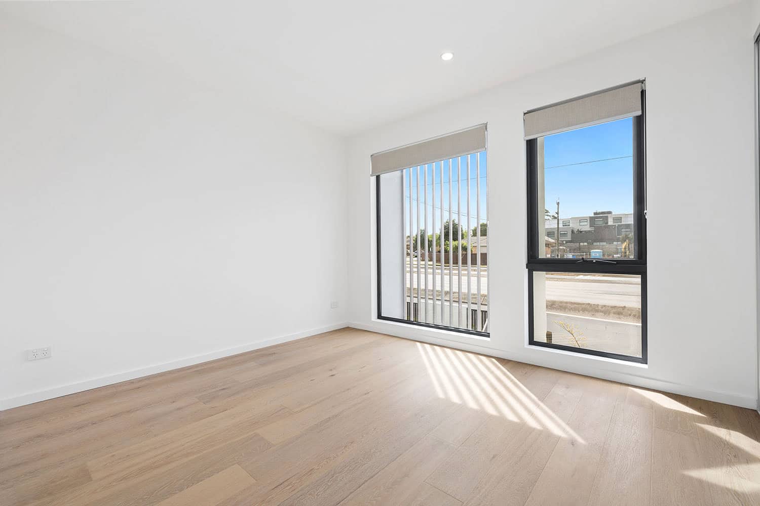 Bright, spacious empty room with large windows and natural light, ideal for property listings and real estate marketing by Ember Estate Agents in Australia.